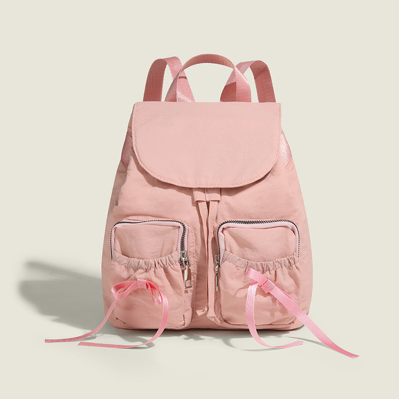 Soft matte nylon drawstring backpack with ruched bow-detail front zip pockets, top carry handle, and silver-tone hardware