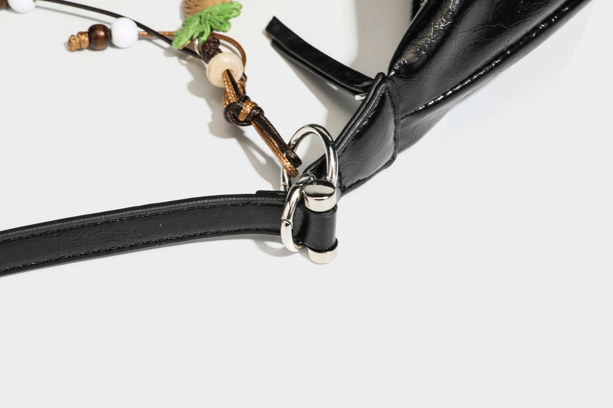 Legere, halbmondförmige Hobo-Schultertasche in glänzender, geknautschter Lederoptik mit schmalem Riemen, Ringbeschlägen in Silberoptik und