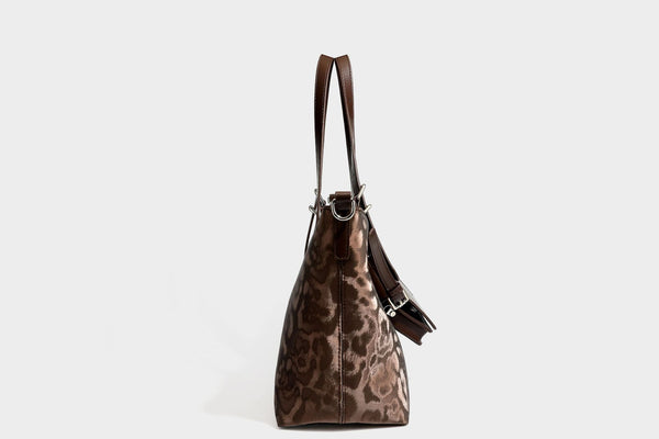 Glossy leopard-print tote bag with leather-look dark trim, dual top handles, detachable shoulder strap, and attached front