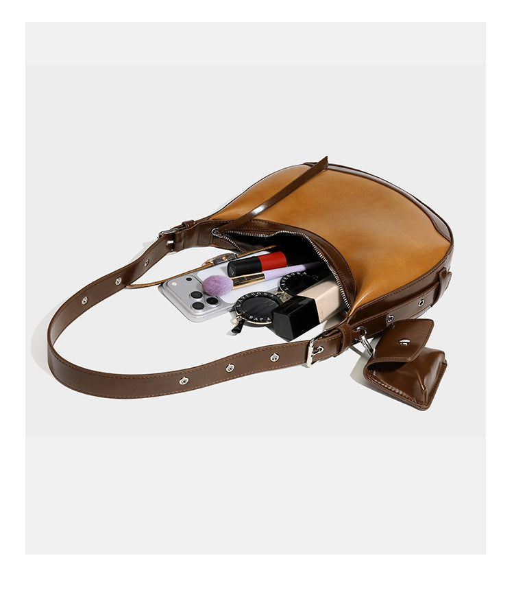 Glossy leather-look crescent hobo shoulder bag with dark contrast trim, silver-tone hardware, and attached mini flap pouch