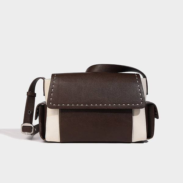 Structured flap crossbody bag in dark brown and cream color-block with white contrast stitching, adjustable shoulder strap