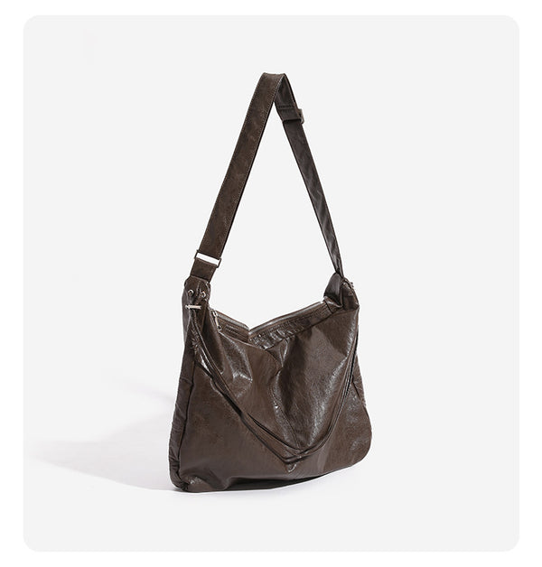Oversized slouchy hobo shoulder bag with glossy crinkled leather-look finish, drawstring gathered sides, and silver-tone