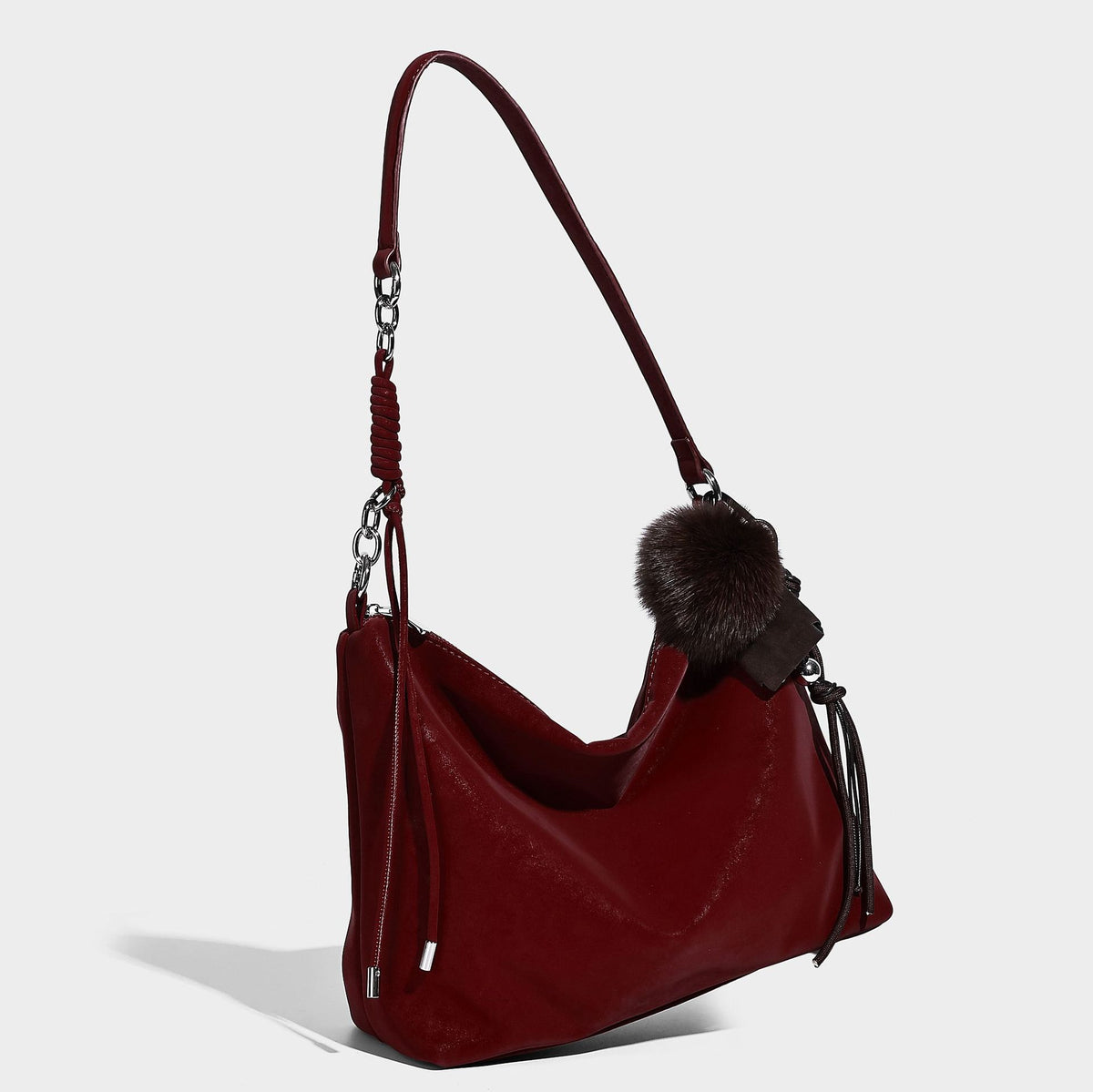 Slouchy matte-finish hobo shoulder bag with tassel cords, silver-tone hardware, and faux-fur pom charm, detail view 6