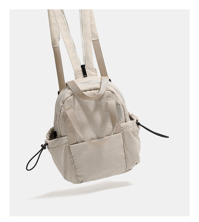 Mini rounded convertible backpack handbag in matte ripstop fabric with dual top handles, adjustable straps, and side, detail