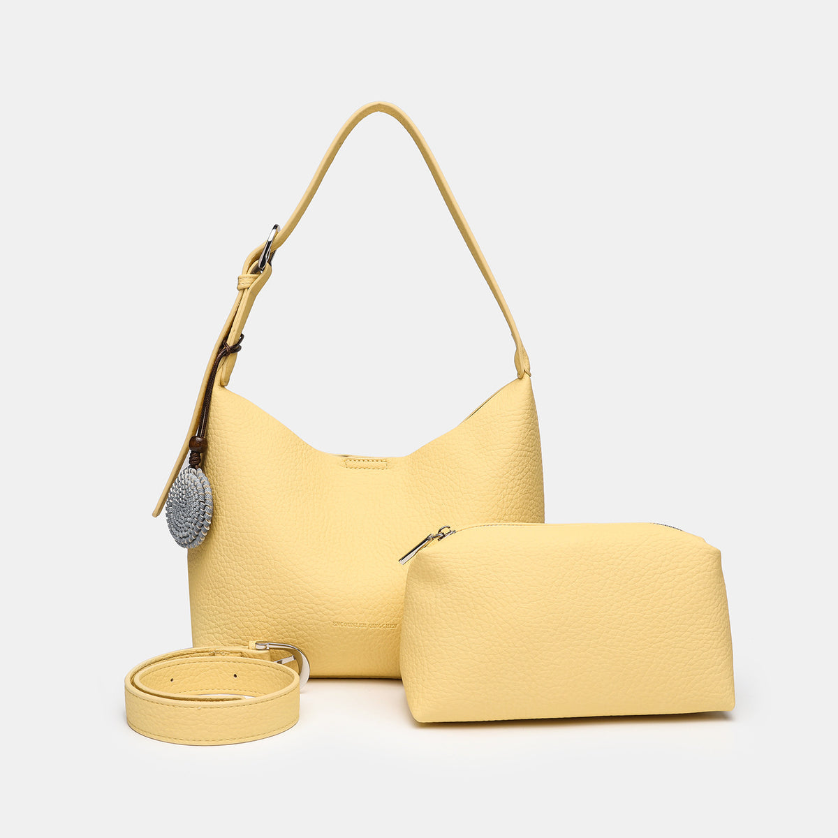 Slouchy hobo shoulder bag in pale yellow pebbled texture with woven charm, adjustable strap, matching zip pouch, and, detail