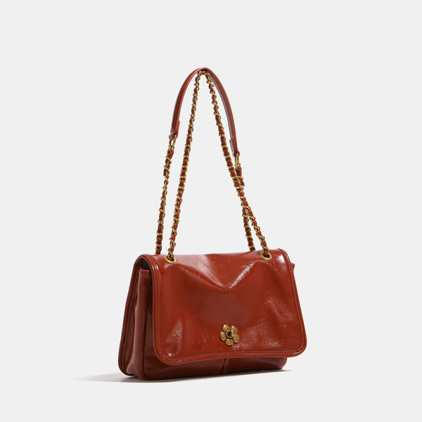 Structured flap shoulder bag with antique gold-tone chain strap and flower turn-lock clasp in crinkled leather-look finish