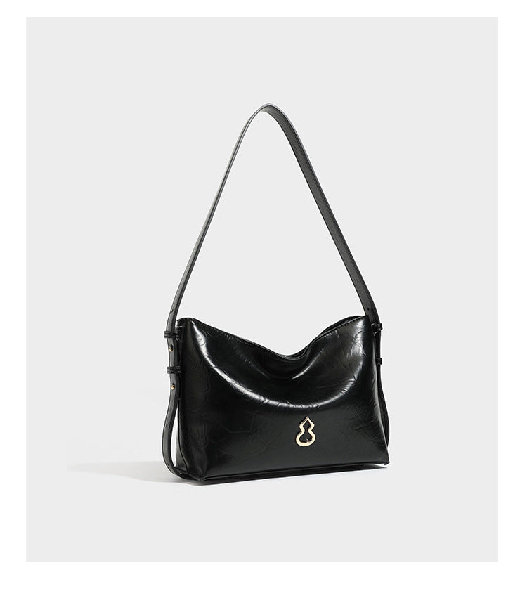 Lässige Hobo-Schultertasche mit offenem oberen Abschluss in glänzender karamellfarbener Lederoptik mit goldfarbenen Logo-Beschlägen und langem, verstellbarem