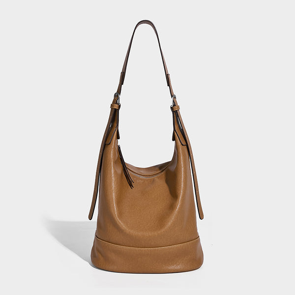 Slouchy bucket hobo shoulder bag in dark brown with glossy leather-look finish, top zip closure, and long adjustable, detail