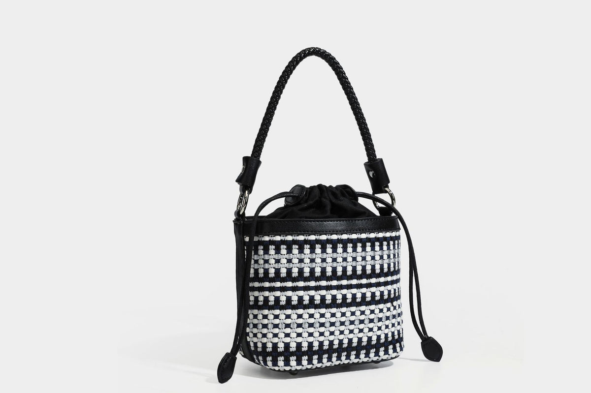 Small structured woven checker bucket bag with braided top handle, drawstring closure, and silver-tone hardware in black