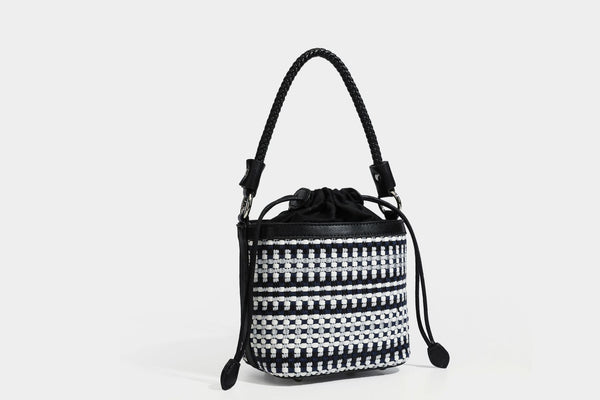 Small structured woven checker bucket bag with braided top handle, drawstring closure, and silver-tone hardware in black