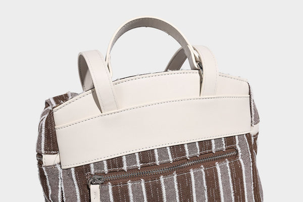 Small structured striped fabric backpack handbag with cream leather-look trim, top handle, and silver-tone hardware, detail