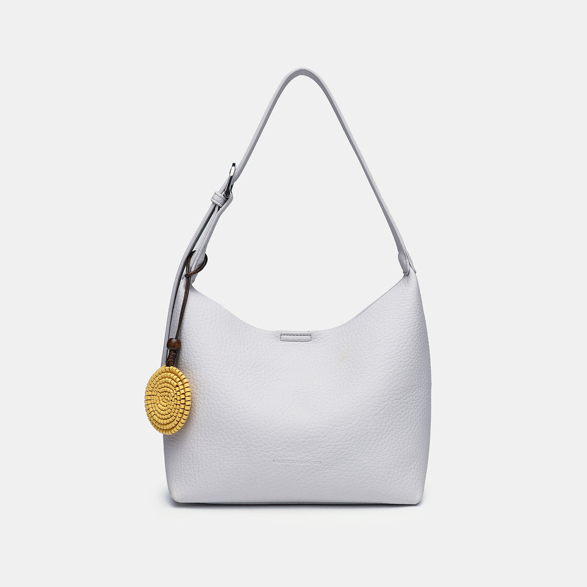 Slouchy hobo shoulder bag in pale yellow pebbled texture with woven charm, adjustable strap, matching zip pouch, and, detail