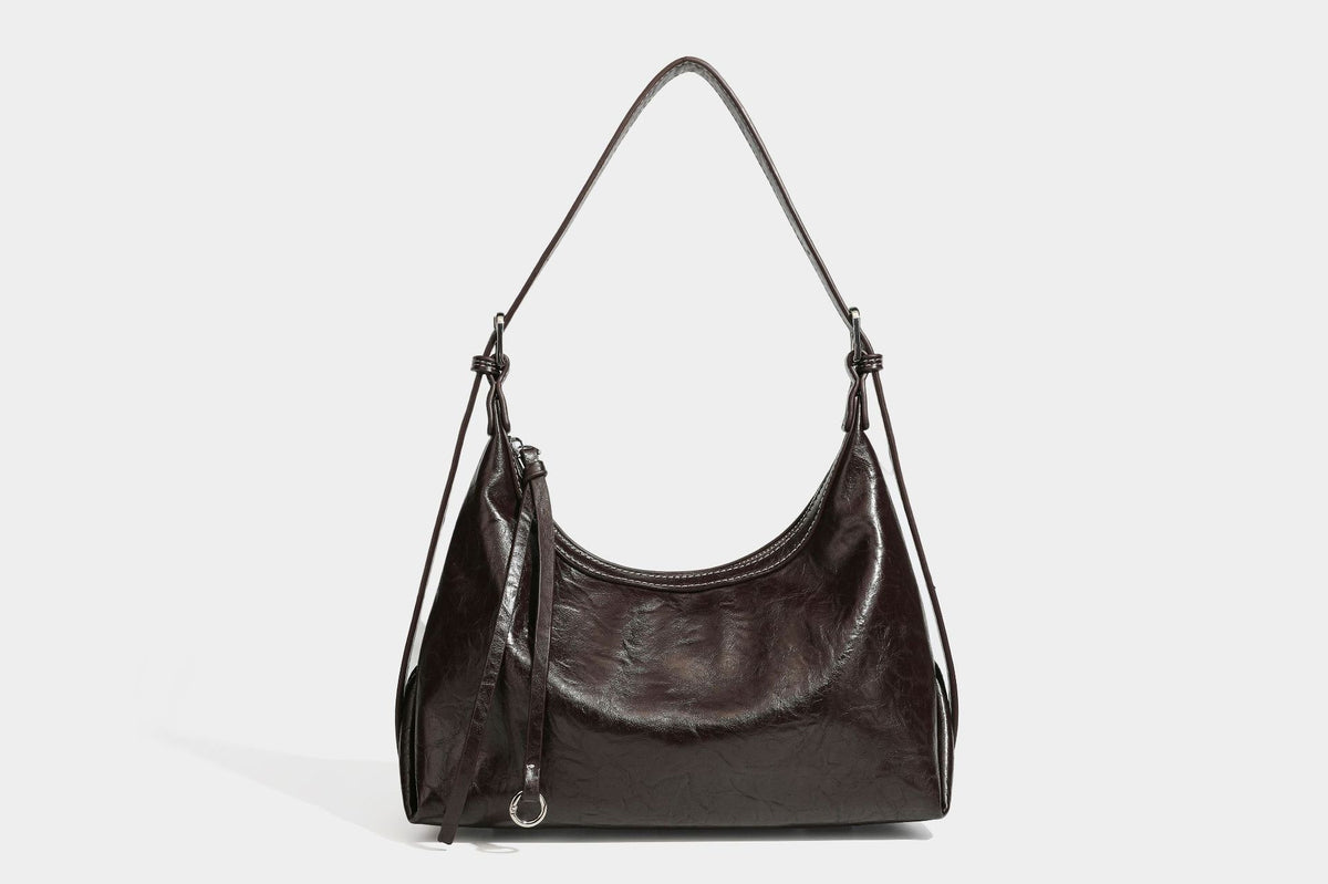 Slouchy hobo shoulder bag in glossy crinkled leather-look finish with zip-top closure and silver-tone ring hardware, detail