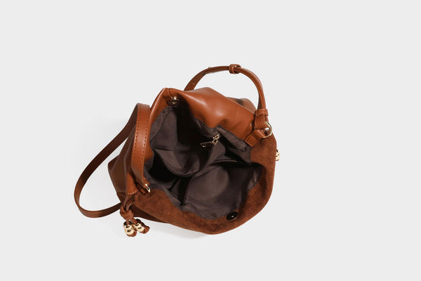 Suede-look drawstring shoulder bag in brown with smooth trim, knotted bead drawstring closure, slim adjustable strap, and