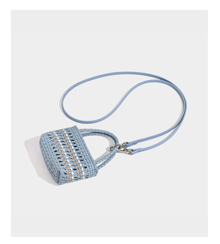 Structured woven bucket tote bag in pastel blue with braided shoulder strap, open lattice weave body, cream drawstring