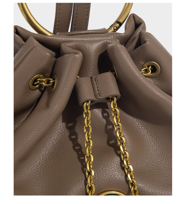 Kleine Bucket-Tasche in genarbter Lederoptik mit Ringgriff in Goldoptik, Medaillon-Anhänger an einer Kette und verstellbarem Rucksack