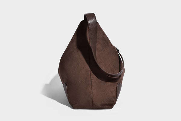 Dark brown slouchy hobo bag with matte suede-look body, smooth leather-look base trim, adjustable shoulder strap, and, detail