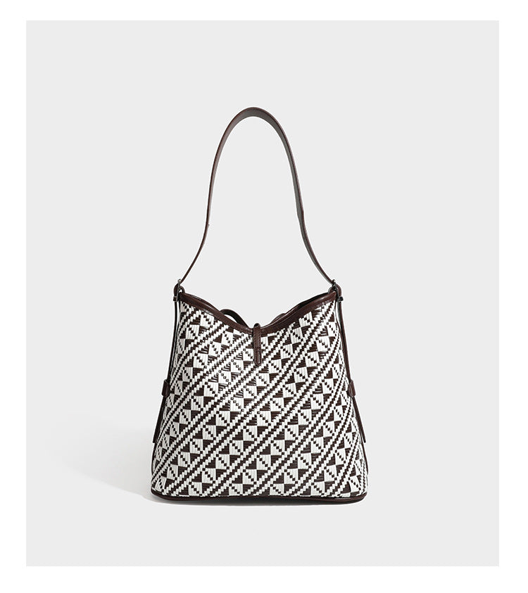 Woven geometric bucket shoulder bag in white and dark brown two-tone pattern with leather-look trim and drawstring top
