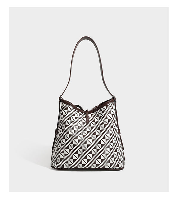 Woven geometric bucket shoulder bag in white and dark brown two-tone pattern with leather-look trim and drawstring top