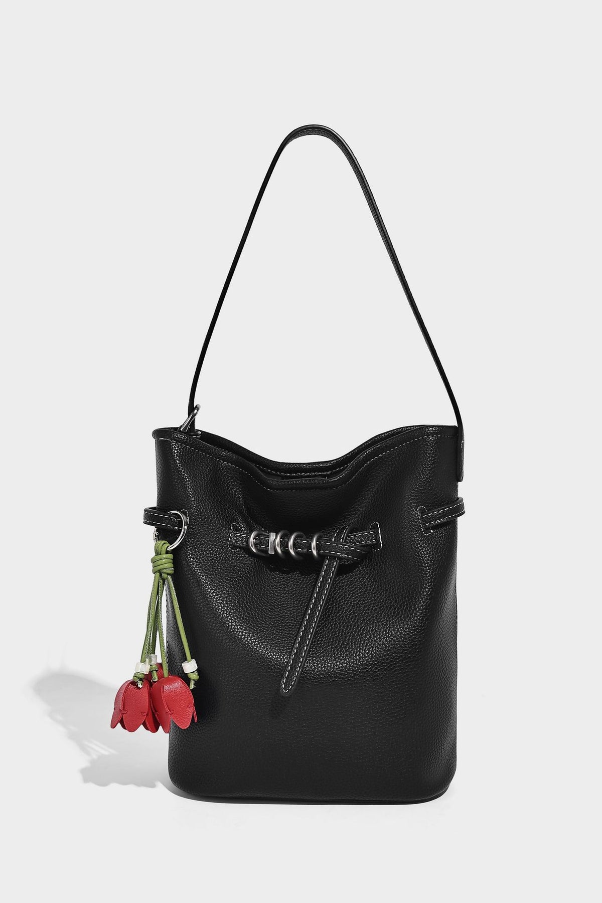Small pebbled leather-look bucket bag with front drawstring toggle hardware and long adjustable shoulder strap, detail view