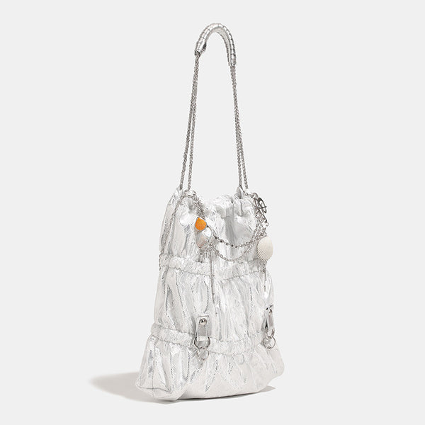 Slouchy lace-texture bucket bag with silver-tone chain strap, draped chain hardware, and shell charms, detail view 2