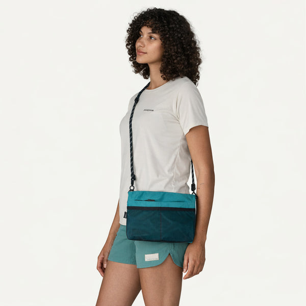 Flat rectangular crossbody bag with mesh front pocket, top zip closure, and adjustable patterned strap, detail view 11