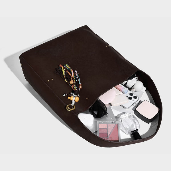 Oversized trapezoid tote bag with matte leather-look finish, gold-tone rivets, and long shoulder strap, detail view 4