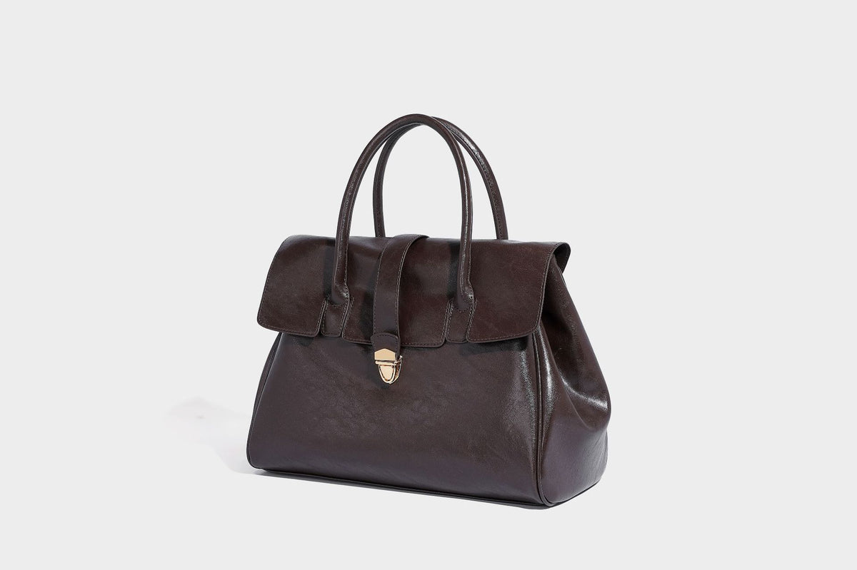 Strukturierte Henkeltasche in glänzender Lederoptik mit Überschlagverschluss, mittigem Riemen, goldfarbenem Drehverschluss und zwei Henkeln