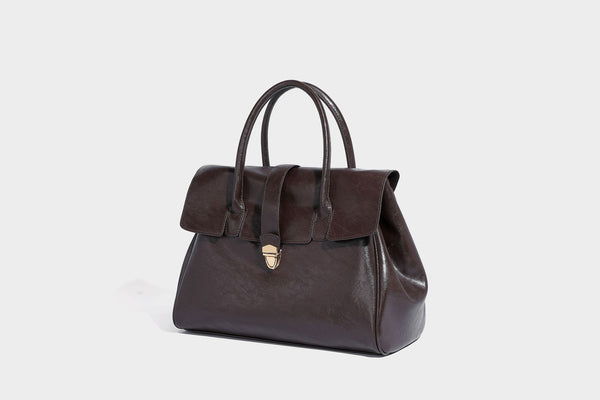Strukturierte Henkeltasche in glänzender Lederoptik mit Überschlagverschluss, mittigem Riemen, goldfarbenem Drehverschluss und zwei Henkeln