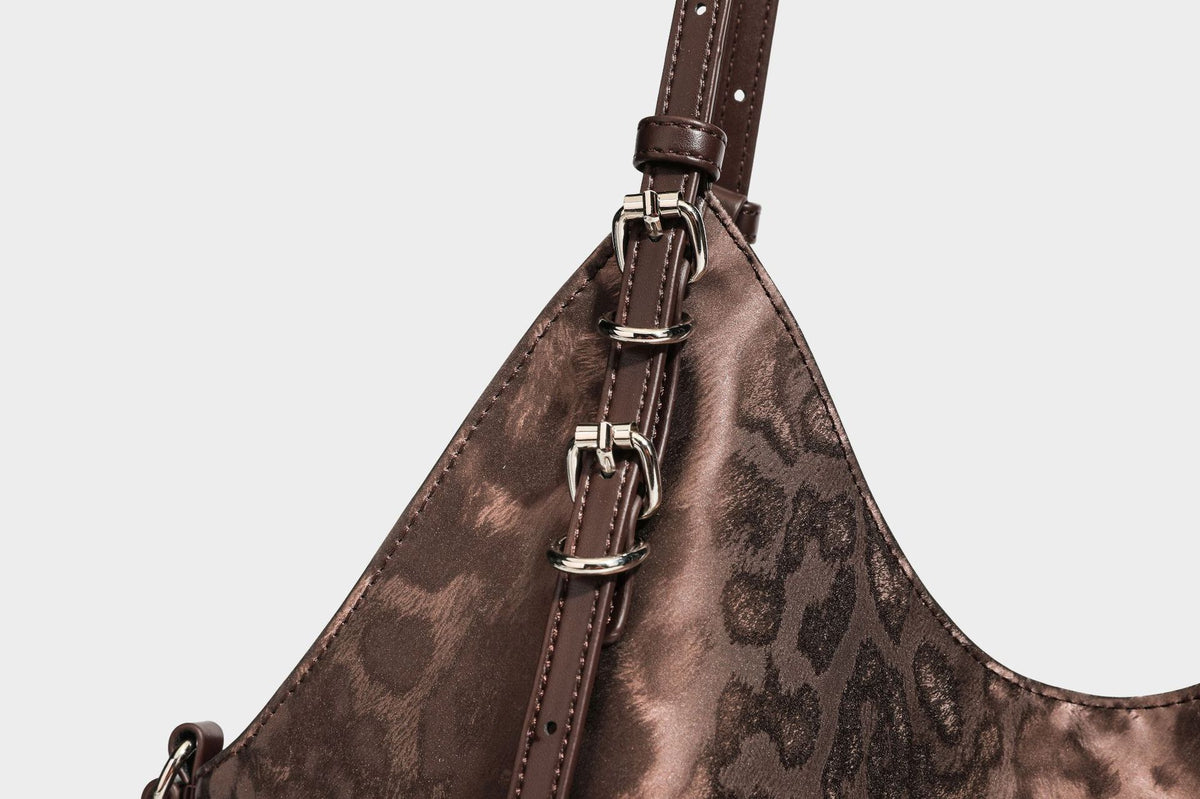 Große, glänzende Hobo-Schultertasche mit Leopardenprint, abnehmbarem Reißverschlusstäschchen und silberfarbenem Seestern-Anhänger, Detailansicht