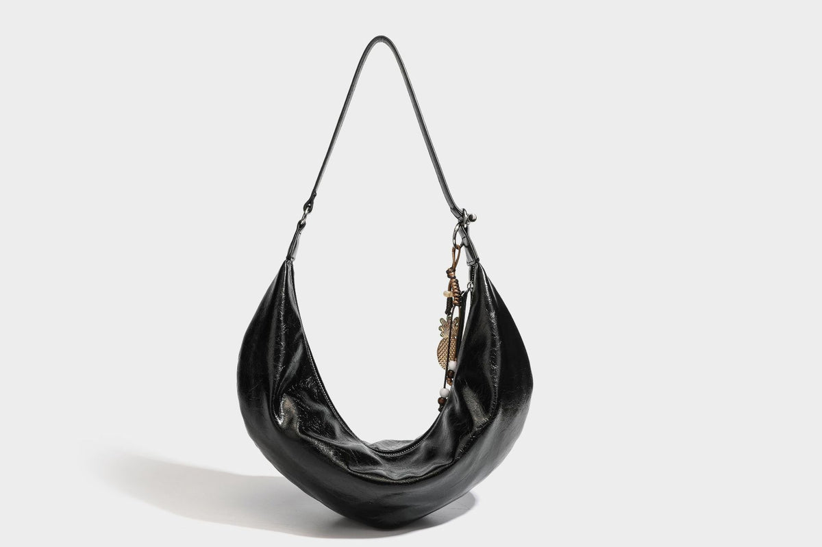 Lässig fallende Hobo-Schultertasche in Halbmondform mit glänzender, geknautschter Lederoptik, schmalem Riemen, silberfarbenen Ringbeschlägen und