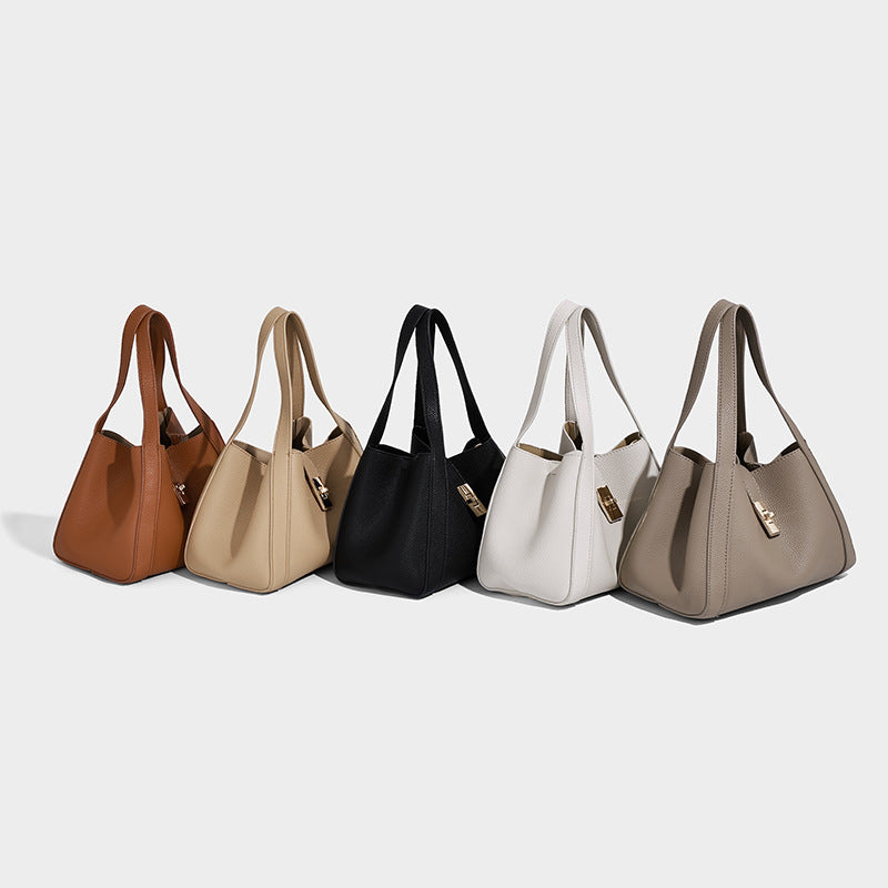 Structured trapezoid tote bag in taupe pebbled leather-look finish with gold-tone turn-lock hardware, dual top handles, and