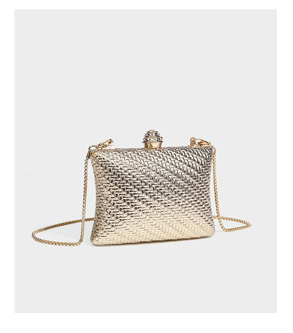 Small structured rectangular metallic woven-texture clutch bag with jeweled knob clasp and gold-tone chain strap, detail view