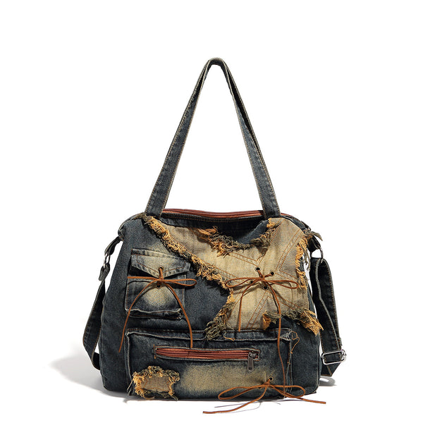 Large distressed denim patchwork shoulder tote bag with frayed panels, leather-look lace detailing, and front zip pocket in