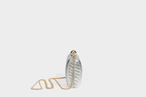 Small structured metallic woven-texture box clutch bag with jeweled kiss-lock dome clasp and slim gold chain strap, detail