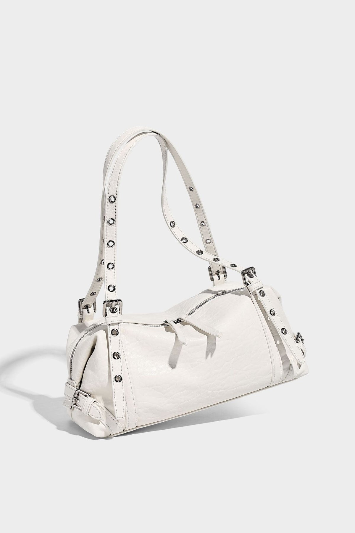 Pale yellow leather-look barrel bag with silver grommet-studded shoulder straps, top zip closure, and pink tulip floral