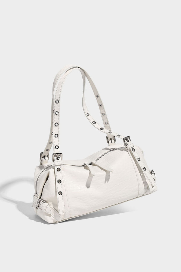 Pale yellow leather-look barrel bag with silver grommet-studded shoulder straps, top zip closure, and pink tulip floral