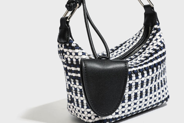 Small crescent shoulder bag in black-and-white woven textile with smooth black leather-look trim, zip-top closure, knotted