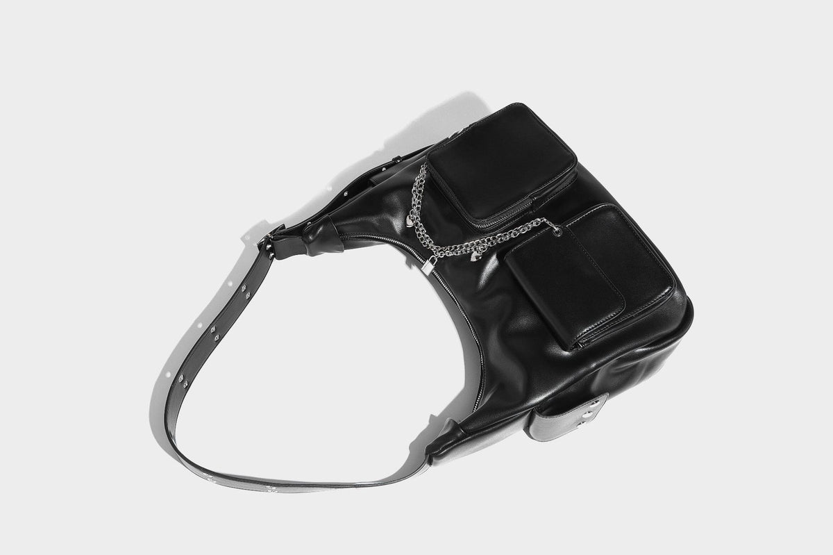 Lässig fallende Hobo-Schultertasche mit glänzender Lederoptik, vorderen Klappentaschen, Kettenapplikationen und silberfarbenen Nietbeschlägen