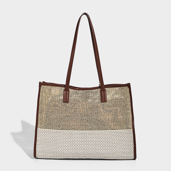 Two-tone woven straw tote bag with leather-look brown trim, long shoulder straps, and knotted tassel charm, detail view 4