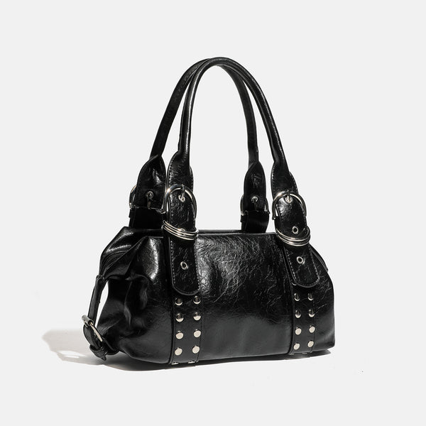 Compact black glossy leather-look satchel bag with silver-tone rivets, buckle hardware, and dual padded top handles, detail