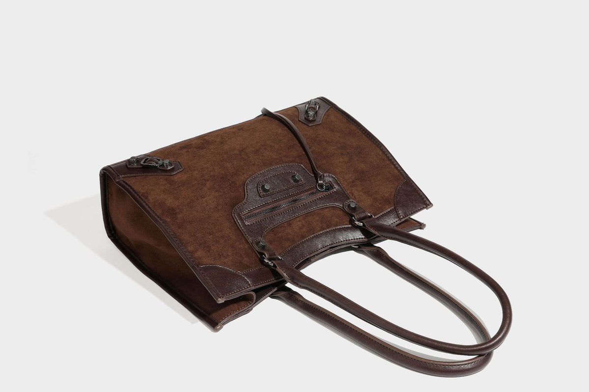 Large structured tote bag with matte suede-like body, smooth leather-look trim, front zip pocket, stud hardware, and