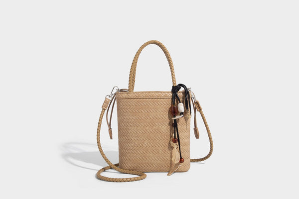Small structured woven-texture tote bag with braided top handles and drawstring inner pouch, detail view 24
