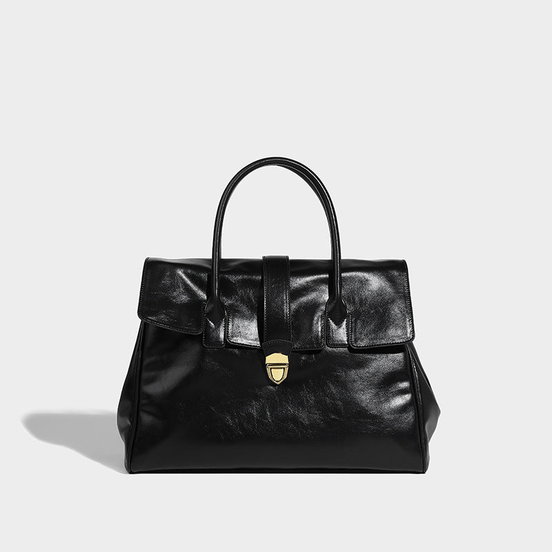Strukturierte Henkeltasche im Shopper-Stil aus glänzender Lederoptik mit Überschlag, Mittelriemen, goldfarbenem Drehverschluss und zwei Henkeln