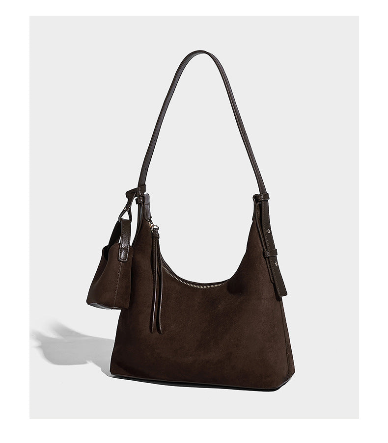 Dark brown suede-look hobo shoulder bag with top zip closure, adjustable strap, and small detachable mini pouch, detail view