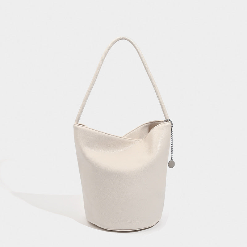 Bucket-Schultertasche aus genarbter Lederoptik mit Ketten- und Scheibenanhänger-Beschlägen sowie einem einzelnen geschwungenen Tragegriff, Vorderansicht