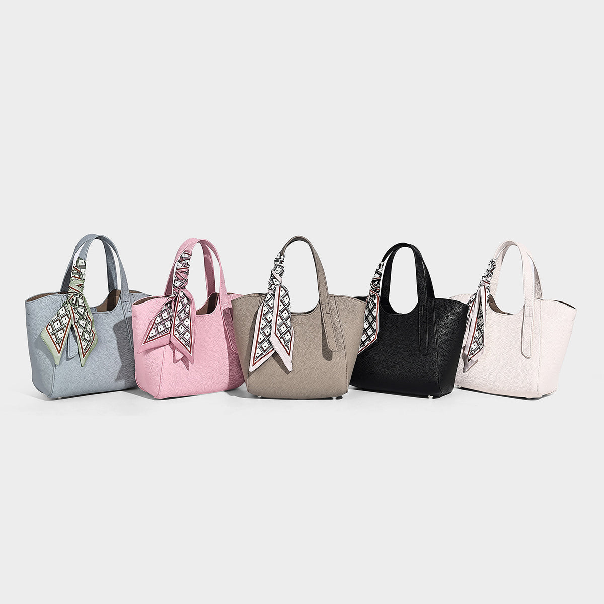 Structured pebbled leather-look tote bag with detachable scarf tie, dual top handles, and adjustable crossbody strap, detail