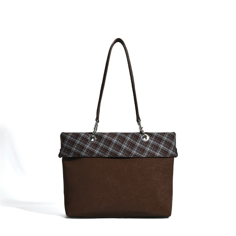 Brown structured tote bag with woven plaid fold-over top panel, silver-tone ring hardware, and long flat shoulder straps