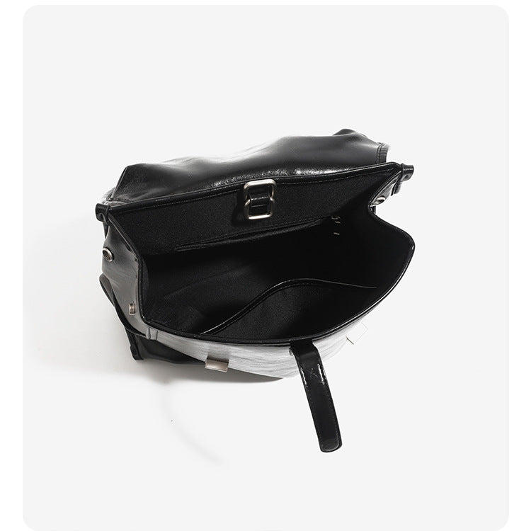 Structured glossy leather-look flap backpack handbag with dual buckle closures, top handle, and silver-tone hardware, detail