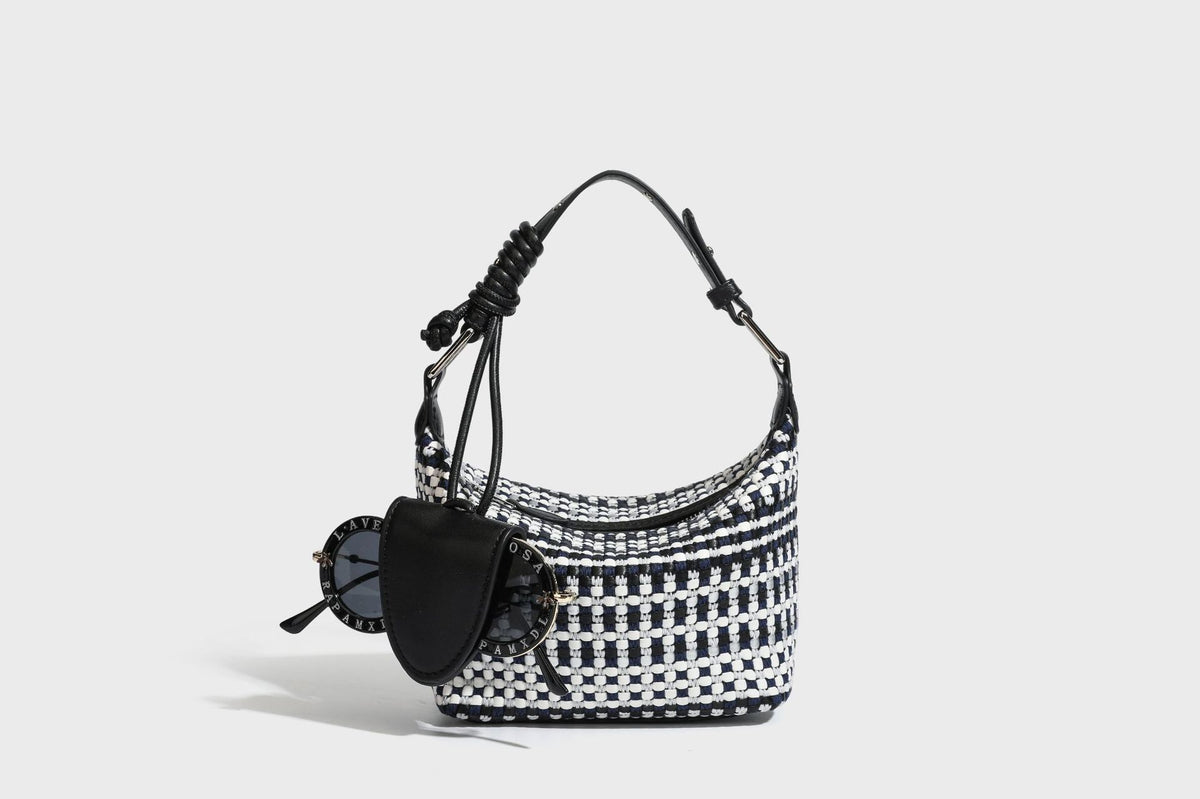 Small crescent shoulder bag in black-and-white woven textile with smooth black leather-look trim, zip-top closure, knotted